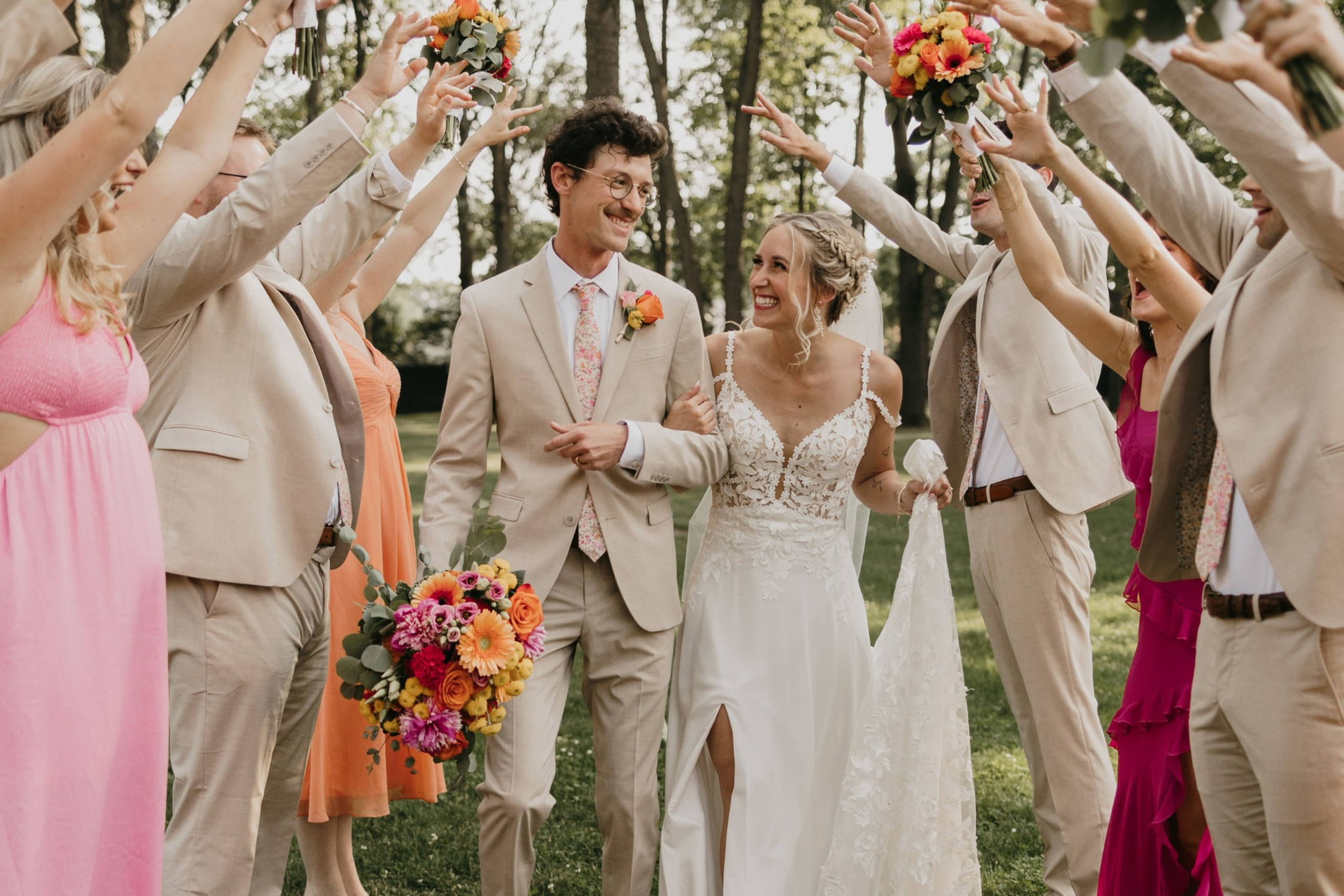 Photo By Taylor Rae Photography Bride and groom walking through a tunnel of their wedding party's outstretched arms outside of Solomon Fowler Mansion