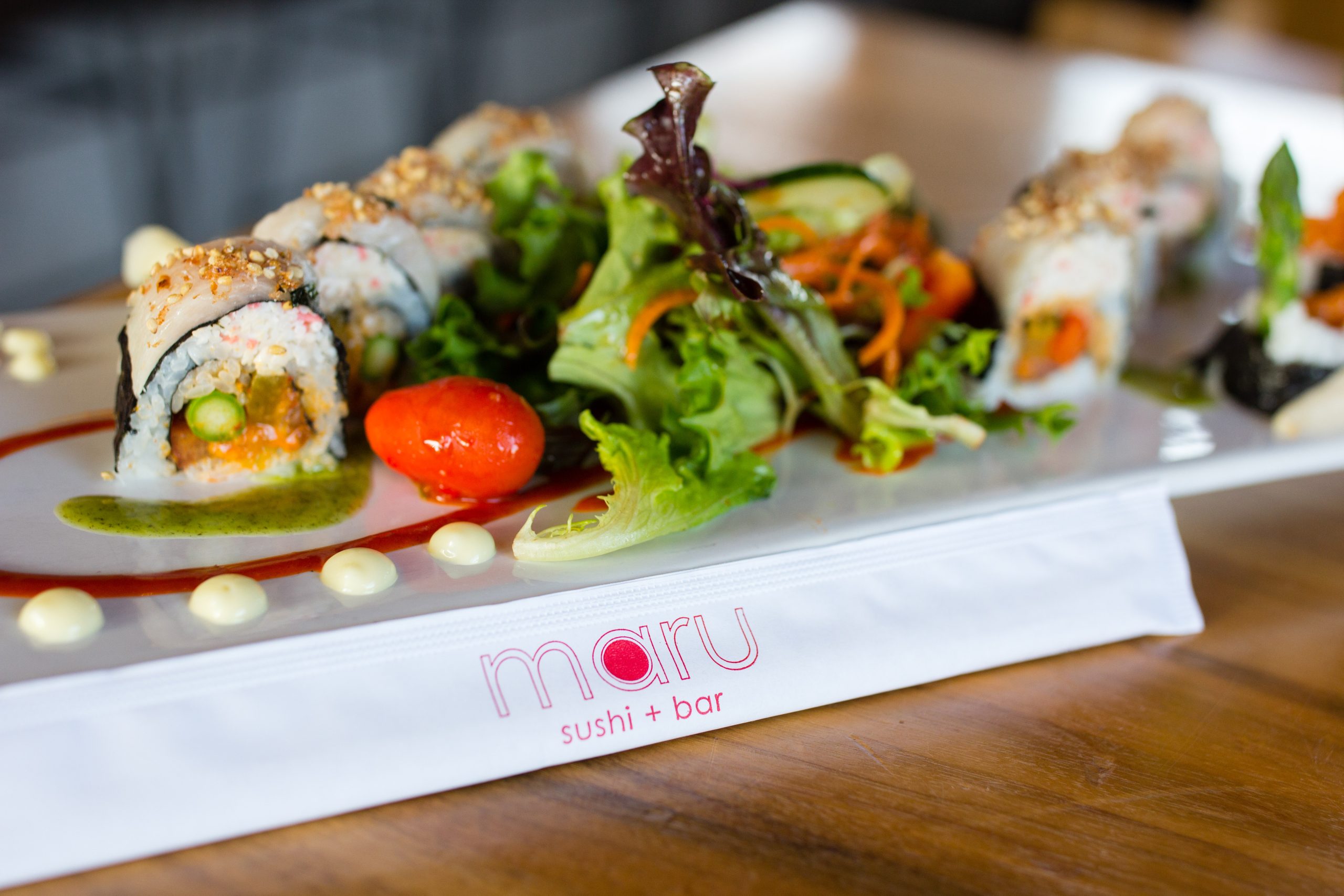 Maru branded chopsticks in front of a beautiful platter of sushi at Maru in Kalamazoo.