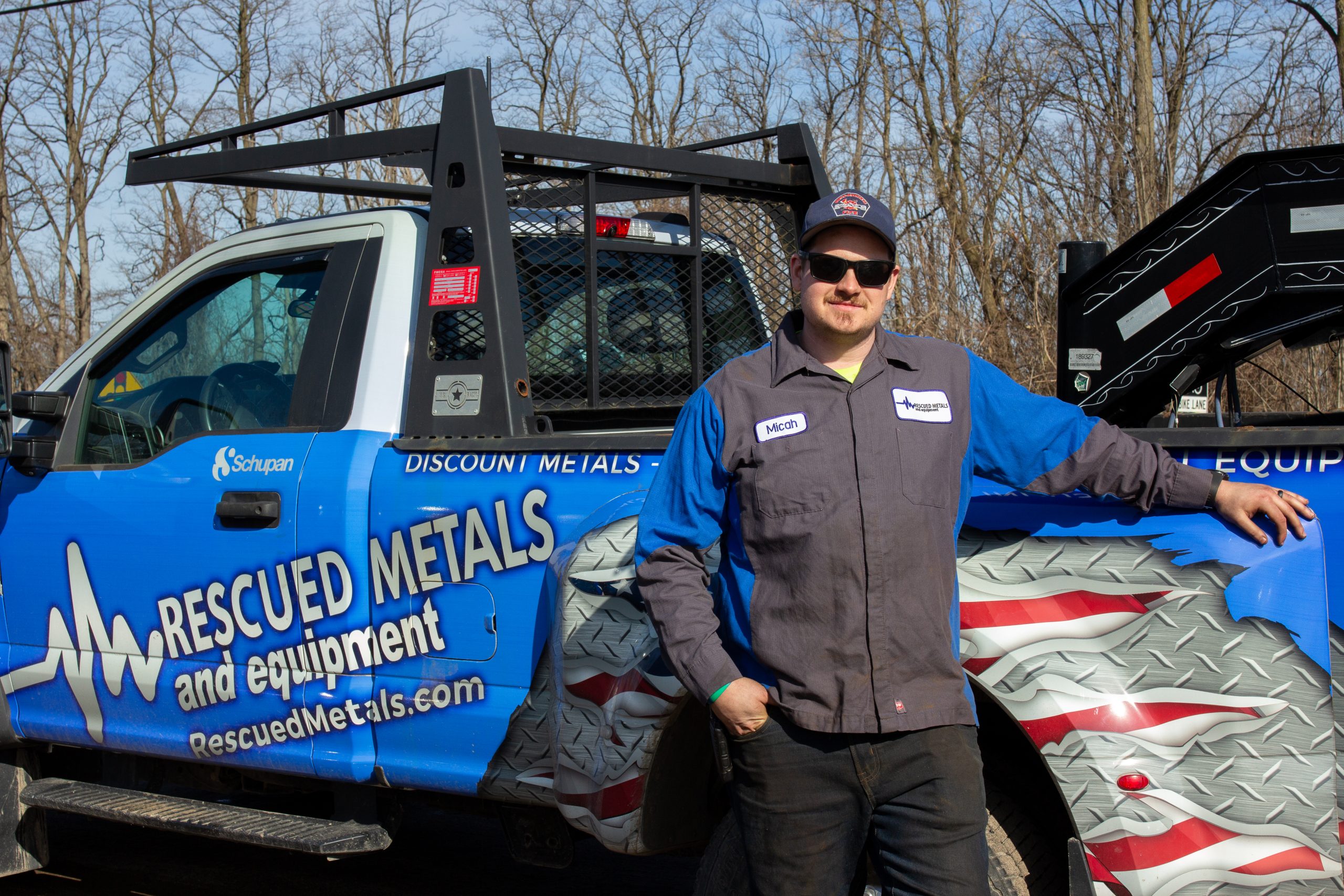Micah Schupan standing beside the branded Rescued Metals truck.